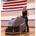 Tomcat MiniMag walk-behind scrubber with operator on gym floor