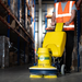 Cimex Cyclone 48 scrubbing a warehouse aisle floor