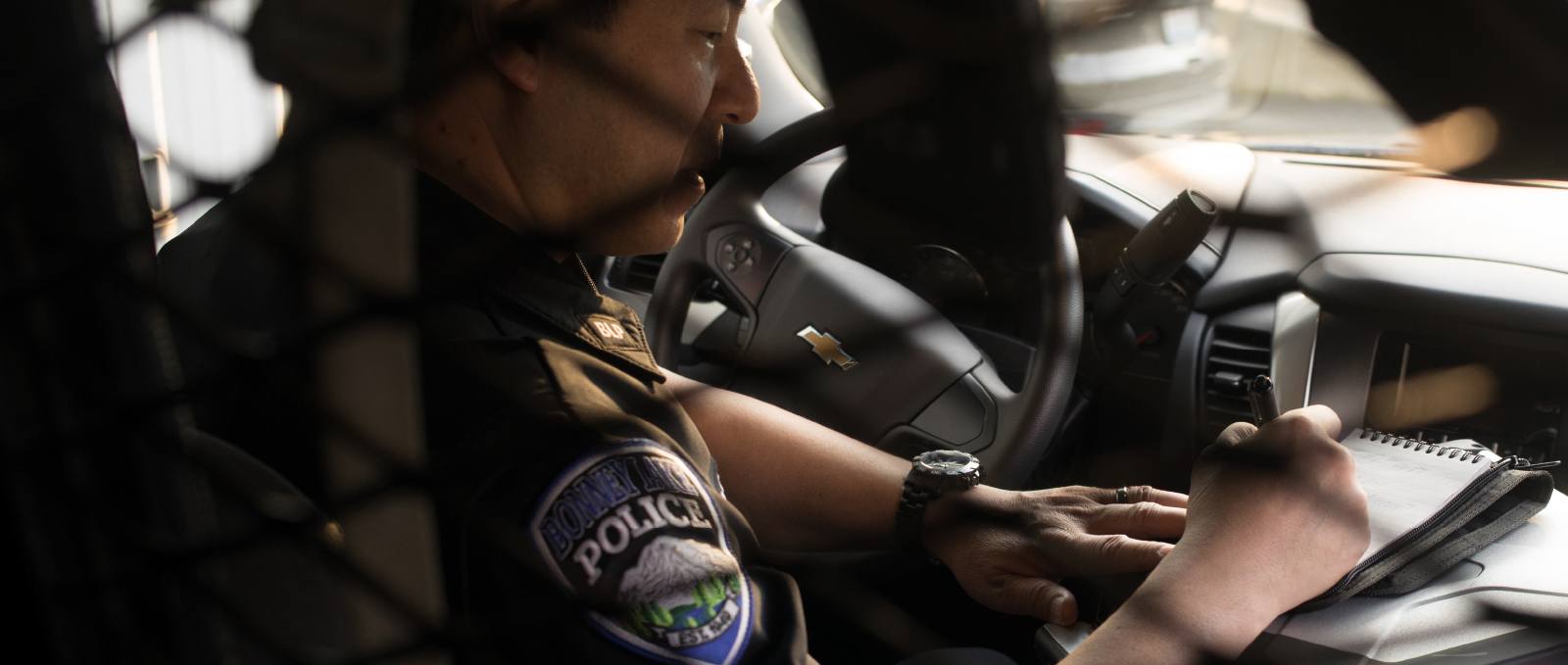 Officer taking notes in the cab of his vehicle.