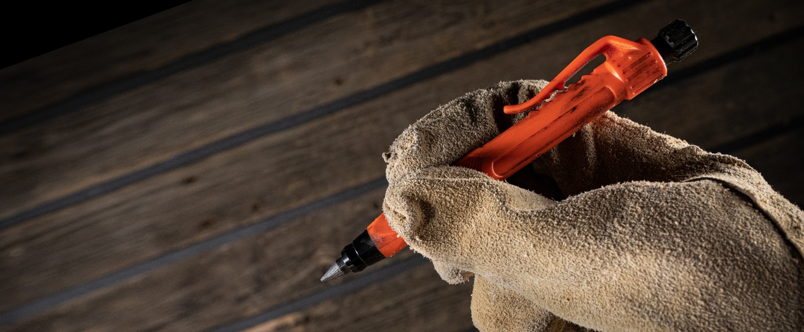 Gravity-Fed Lead Holder being held by a gloved hand.