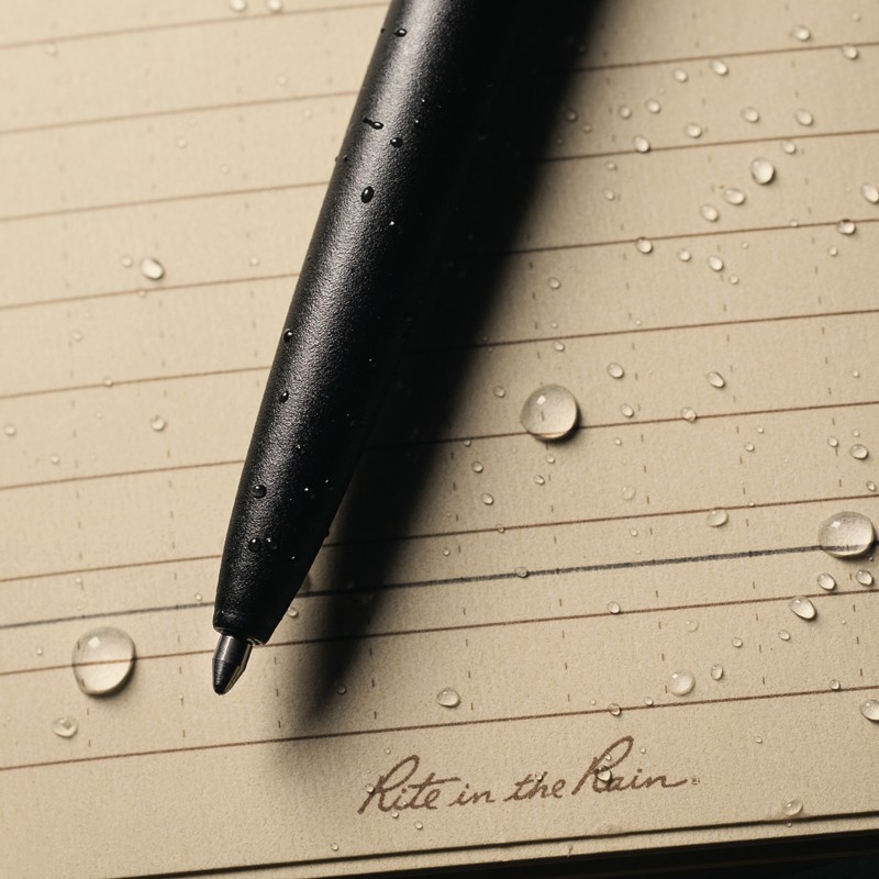 All-weather pen sitting on wet paper, ink written through water drops.