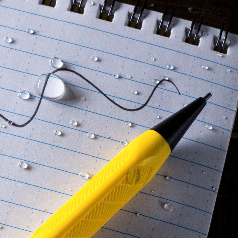 Mechanical pencil resting on notebook with writting through water drops.