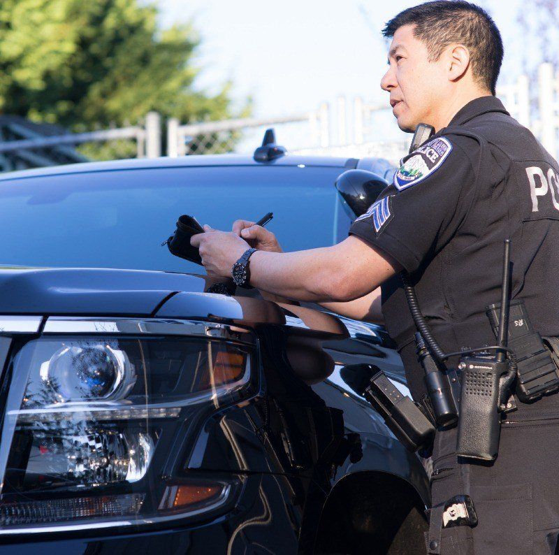 Officer taking notes on the hood of his vehicle.