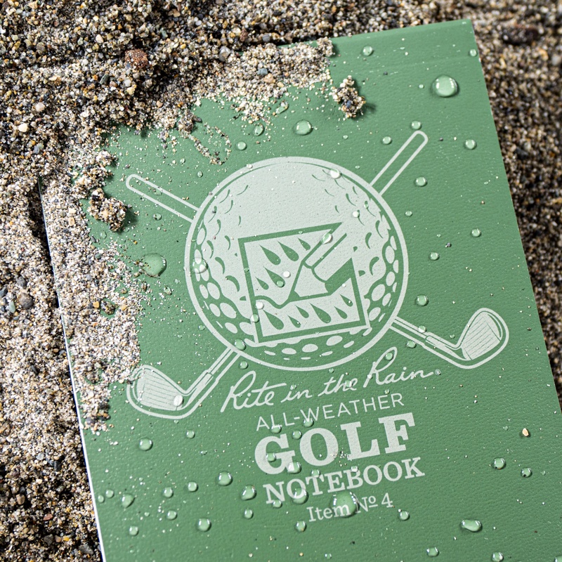 Golf notebook cover laying in sand pit.