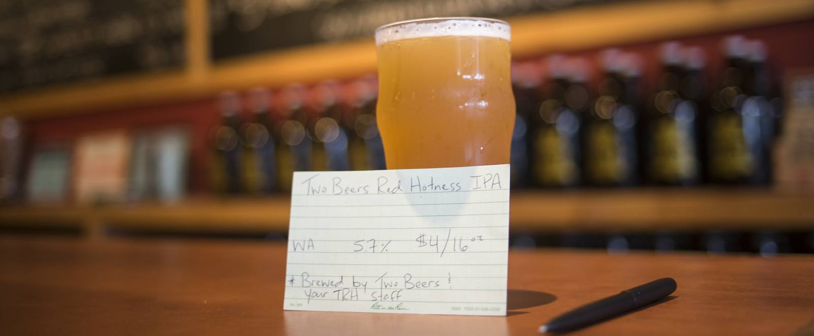 weatherproof index card leaning against a glass of beer