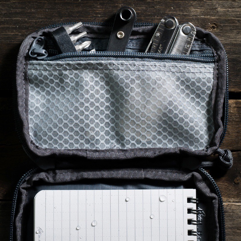 Pocket organizer filled with gear and notebook.