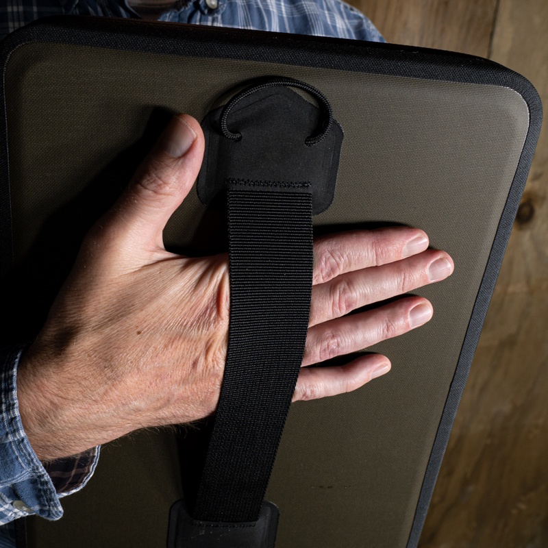 Hand placed throught the webbing handle on the back of the desk.