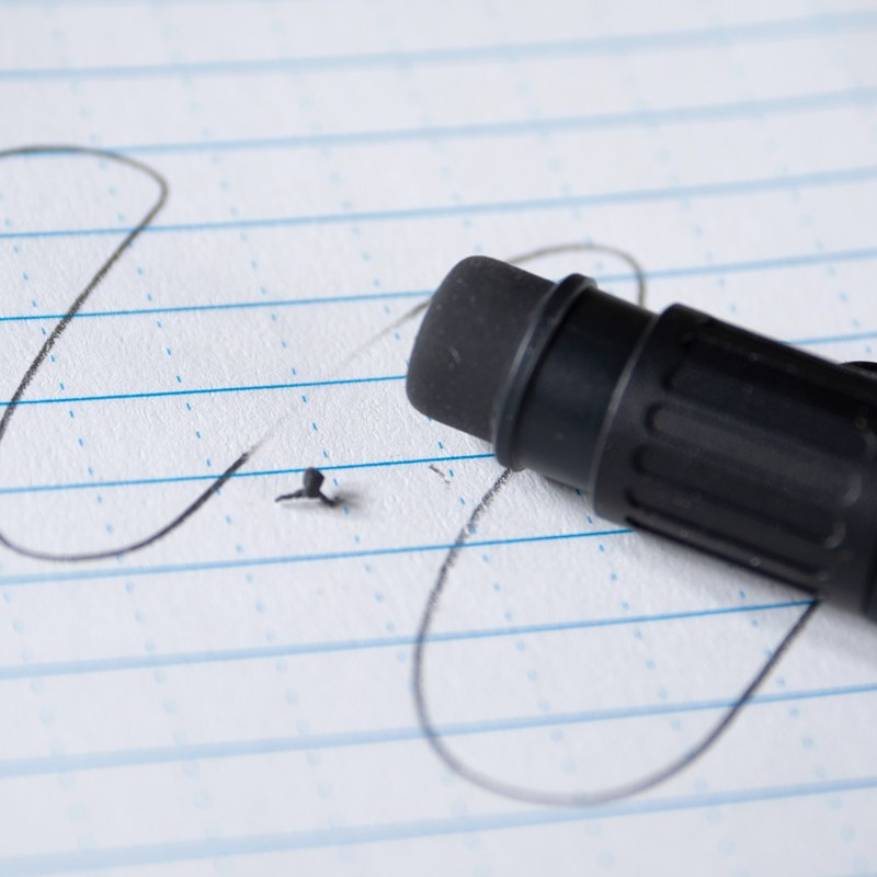 No. 15 eraser sitting on paper with pencil lines partially erased.