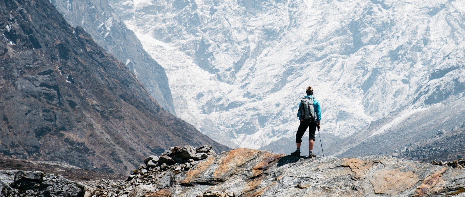 Mountaineer on a mountain top looking down at glacier.