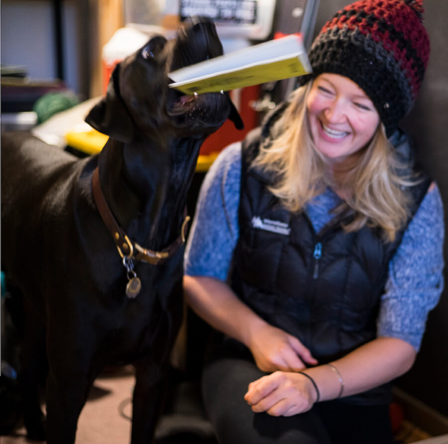 mountaineer laughing as dog takes notebook